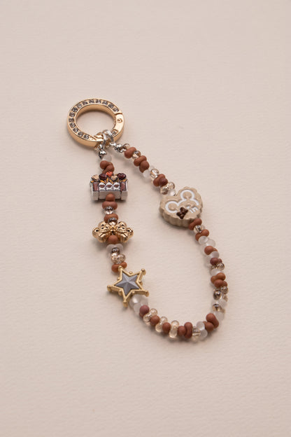Little Luck beaded phone charm attached to phone with tether tab